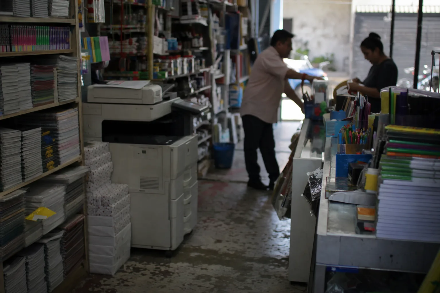 Neighborhood stationery store with notebook shelves and a photocopier