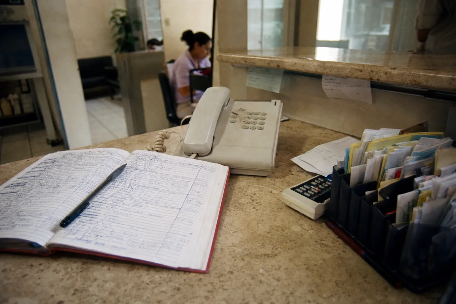 Clinic reception with a paper agenda full of handwritten appointments